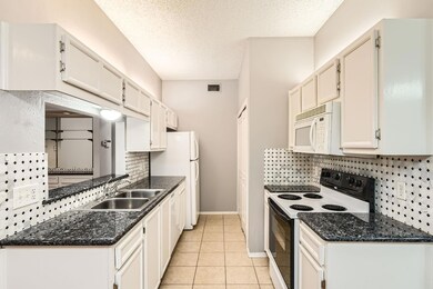 Kitchen featuring a sink, white appliances, a tex