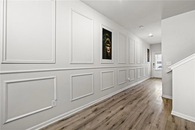 Hallway with baseboards, wood finished floors, and