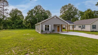 View of front of house featuring a front yard, driveway, and a porch