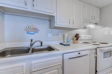 Kitchen featuring under cabinet range hood, white 