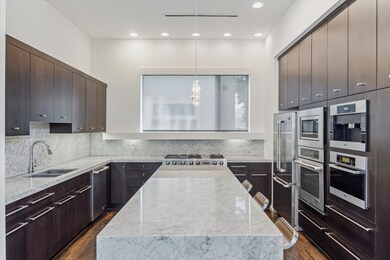 A large marble island with bar seating provides lu