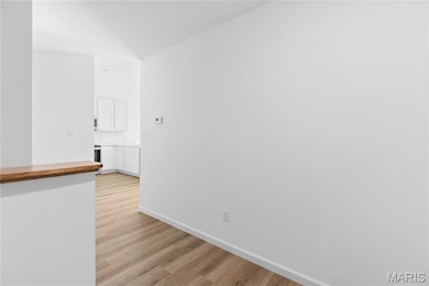 Spare room featuring light wood-type flooring and baseboards