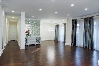 Spare room with ornamental molding, dark wood-style flooring, a chandelier, and recessed lighting
