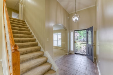 Tiled entrance foyer featuring baseboards, arched 