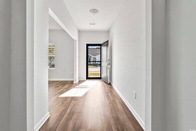 Doorway with wood finished floors and baseboards