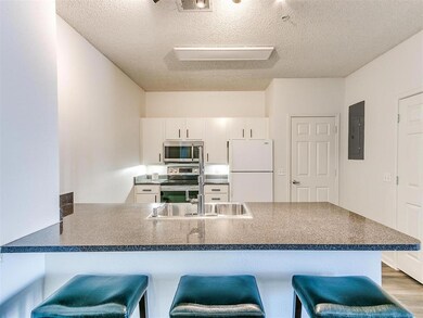 Kitchen featuring electric panel, dark countertops