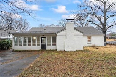 Rear view of house featuring a yard and central AC unit