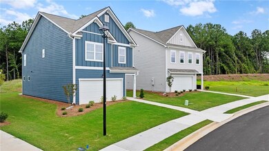 Craftsman house featuring board and batten siding, a front lawn, a garage, and roof with shingles