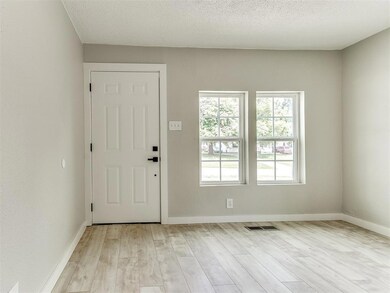 Foyer with light wood-type flooring and a textured