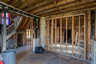 Living room with half pillars leading to the front entry.