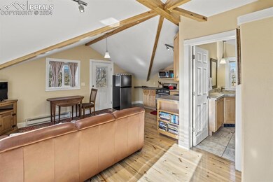Living room with lofted ceiling with beams, sink, 