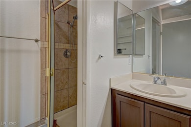 Bathroom featuring a stall shower, vanity, and a t