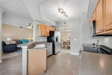 Kitchen featuring a sink, stainless steel appliances, open floor plan, light brown cabinetry, and ceiling fan