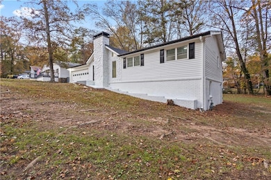 View of side of home featuring a chimney and brick siding