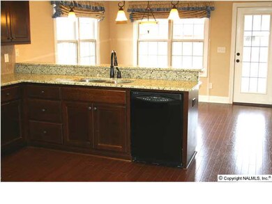 ...snack bar with pendant lighting, walk-in pantry, hardwood floors and more!