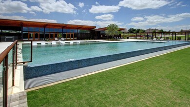 Community pool with a patio area and a lawn