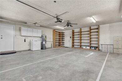 Garage featuring strapped water heater, washer / d