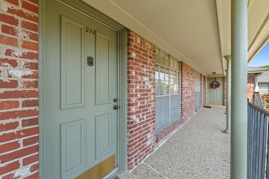 View of exterior entry with brick siding and a po