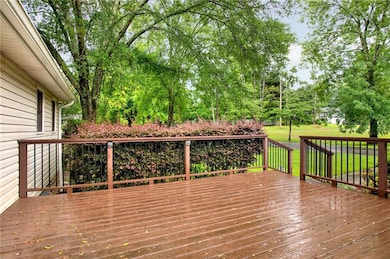 Wooden deck with a yard and view of wooded area