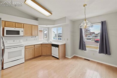 Kitchen with lofted ceiling, white appliances, a n