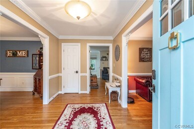Foyer entrance featuring crown molding and light h
