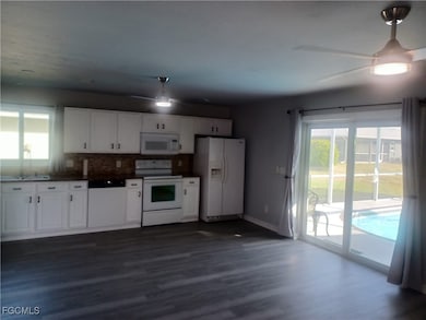 Kitchen featuring ceiling fan, white appliances, and plenty of natural light