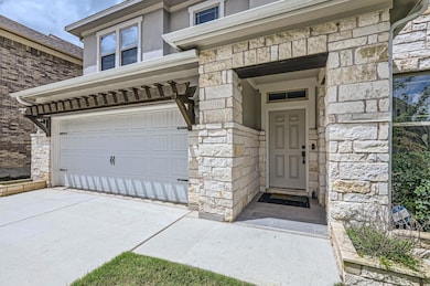 Doorway to property featuring stone siding, a gar