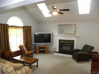 Great room with carpet, cathedral ceiling, 2 skylights, ceiling fan, gas fireplace