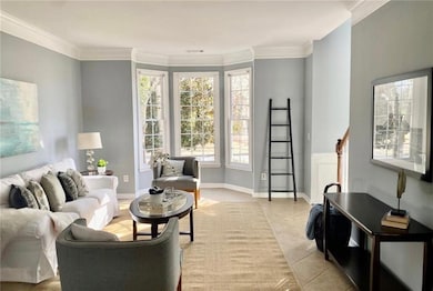 Living room with light tile patterned floors and crown molding