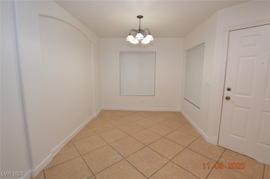 Unfurnished dining area with a chandelier and light tile patterned floors