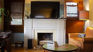 Living room with wood finished floors and a tile fireplace