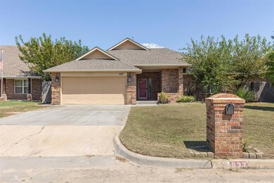 Ranch-style house featuring roof with shingles, a front yard, a garage, concrete driveway, and brick siding