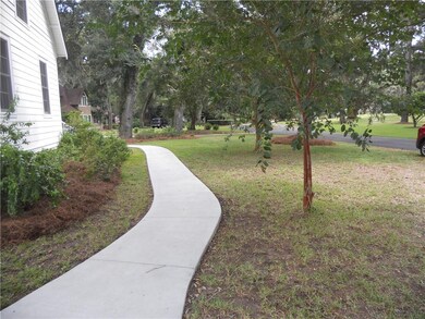 Newly poured sidewalk joins the driveway to the fr