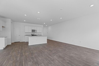 Kitchen featuring open floor plan, white cabinetr