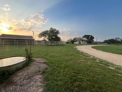 Yard at dusk featuring driveway and fence