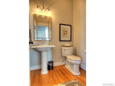 The powder room features gleaming hardwood floors 