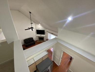 Staircase with vaulted ceiling, a ceiling fan, and recessed lighting