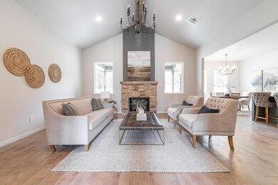 Living room with a fireplace, a chandelier, light 