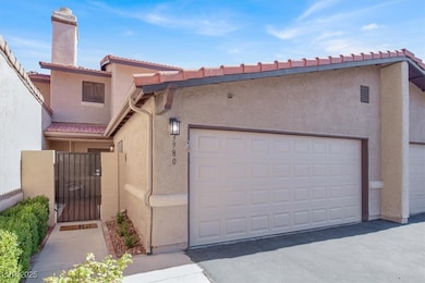 Mediterranean / spanish-style home featuring a gate, a tiled roof, stucco siding, and a chimney