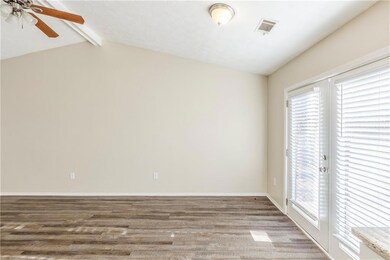 Empty room with visible vents, baseboards, lofted 