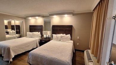Bedroom with crown molding, dark wood-style flooring, a textured ceiling, and a wall mounted AC