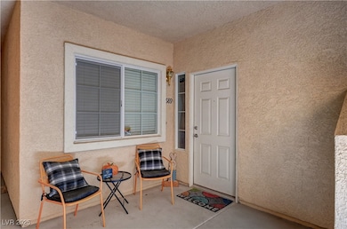 View of exterior entry with stucco siding and a pa