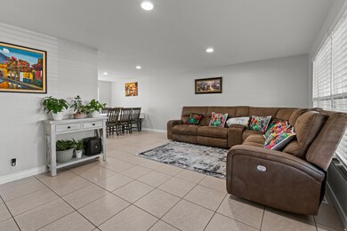 Living room with light tile patterned flooring and recessed lighting