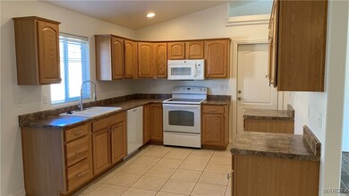 Kitchen with light tile patterned floors, white ap
