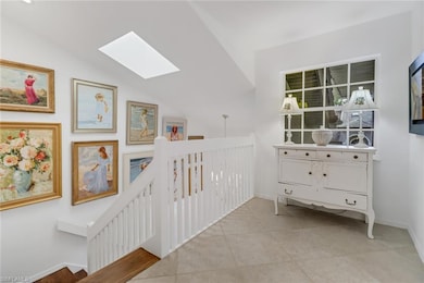 Hallway with lofted ceiling with skylight