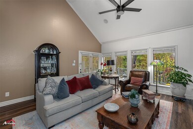 Living room featuring ceiling fan, high vaulted ce