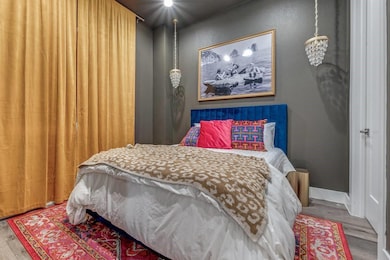 Bedroom featuring baseboards and wood finished flo