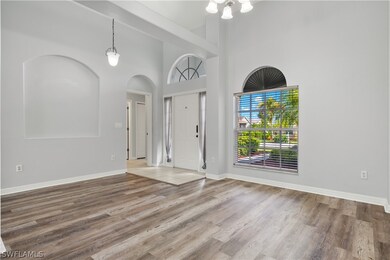 Foyer entrance featuring hardwood / wood-style floors and a towering ceiling