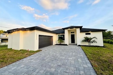 Prairie-style house featuring a garage, decorative driveway, stucco siding, and a front lawn