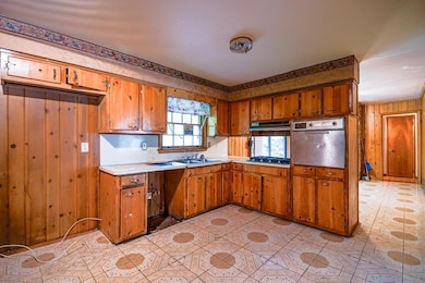 Kitchen featuring wood walls, stainless steel appl